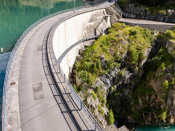 istock Curved Concrete Dam Wall with Mountain Alpine Lake 2228749397
