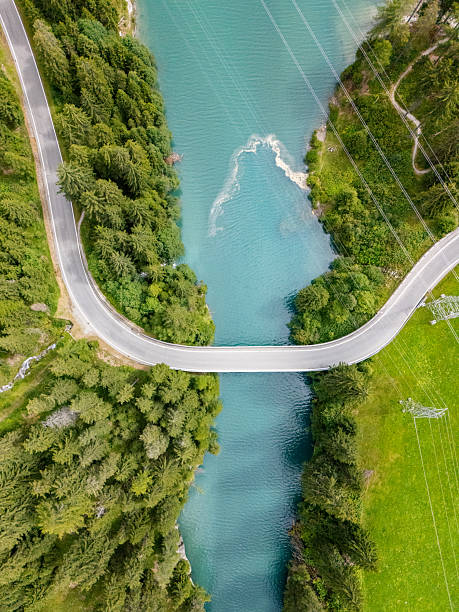 istock Curved Road Bridge Over Clear Blue River 2228750463