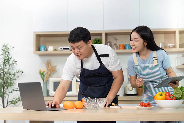 istock Cooking Class: Couple Learning Recipes on Laptop in Kitchen 2228753460