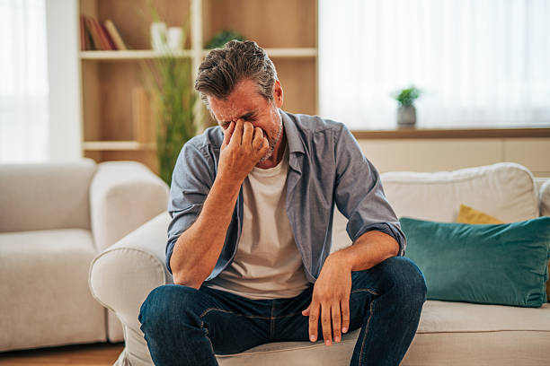 istock Mature man sitting on sofa at home feeling stressed and anxious 2228754474