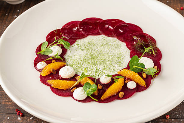 istock Beet carpaccio with orange slices, fresh greens and cream dots 2228754546
