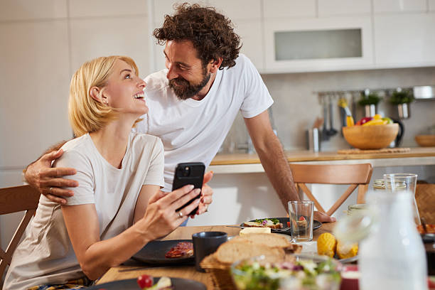 istock Couple enjoying a cozy meal at home while sharing a joyful moment and using a 2228754607