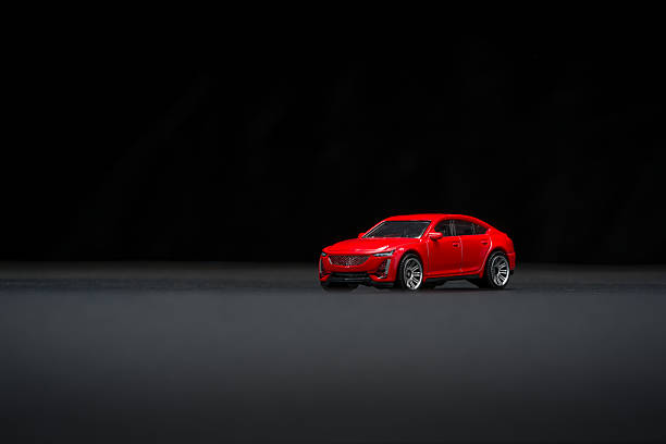 istock Miniature red SUV toy car on black background with dramatic lighting 2228754697