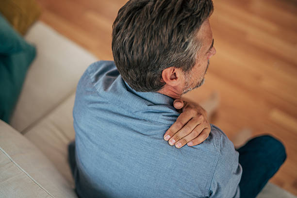 istock Mature man experiencing shoulder pain while sitting on sofa 2228754833