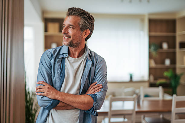 Happy mature man smiling and looking away at home