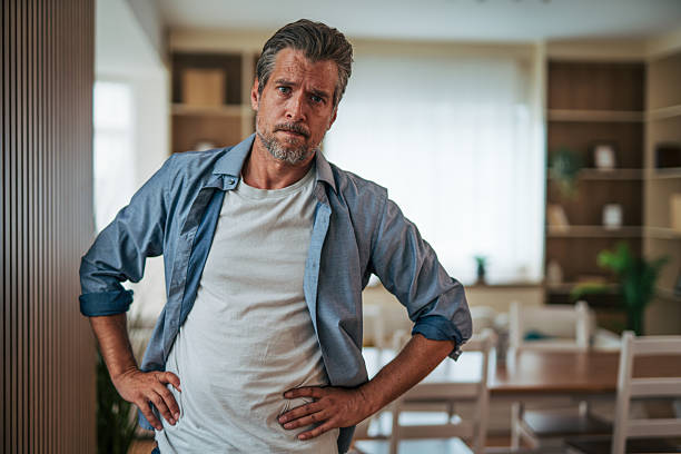 istock Serious mature man posing with hands on hips at home 2228755155