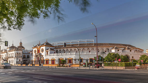 Plaza de Toros de la Real Maestranza de Caballeria de Sevilla timelapse hyperlapse. Historic bullring in Seville, Spain, known for its bullfighting festivals. Traffic passing in front of its facade