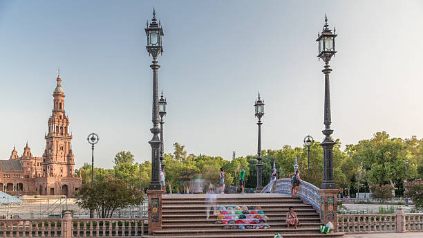 Plaza de Espana in Seville timelapse hyperlapse, a grand architectural complex in Maria Luisa Park built for the Ibero-American Exposition. Bridge with tourists, canal and vintage streetlights