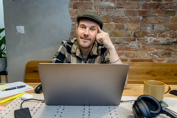 istock Man working on laptop in modern workspace with exposed brick wall and cozy atmosphere 2228758506