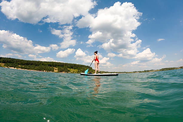 Woman Paddleboarding on a Lake Summertime