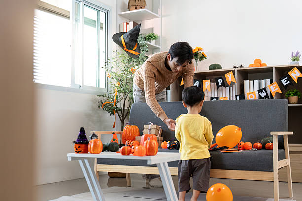 istock Halloween Spirit. Father and son sharing a festive moment while decorating. 2228760078
