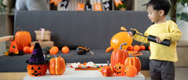 istock Halloween Fun. Child playing with pumpkins and decorations in a festive atmosphere. 2228760163
