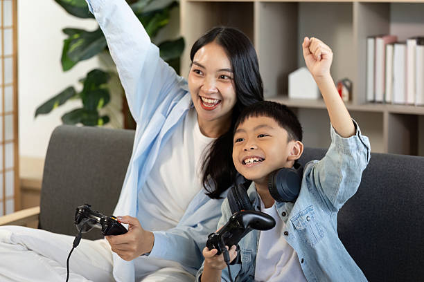 istock Celebrating Victory. Mother and son cheering during a gaming session. 2228760825