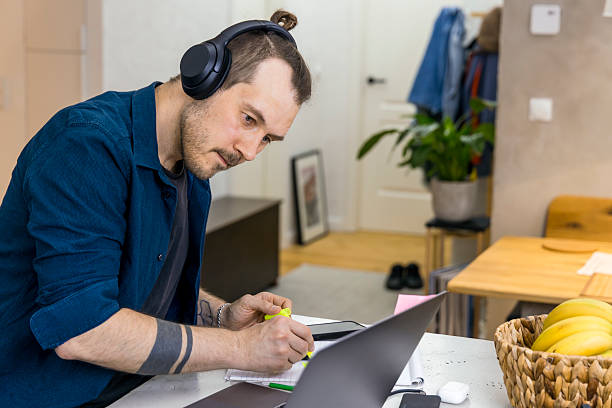 Focused individual working from home at a stylish desk with headphones on