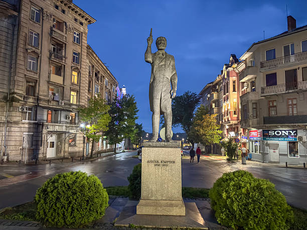Ruse , Bulgaria -May 26 , 2025 ; The Angel Kanchev Monument in Ruse, Bulgaria, honoring the 19th‑century revolutionary hero. The statue stands in the historic city center, surrounded by classic European architecture and illuminated evening streets after the rain.