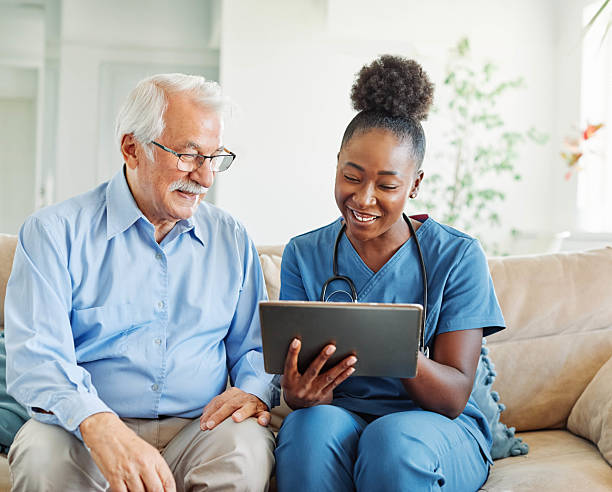 istock nurse doctor senior care tablet computer technology showing caregiver help assistence retirement home nursing elderly woman african american black happy laughing man 2228763061