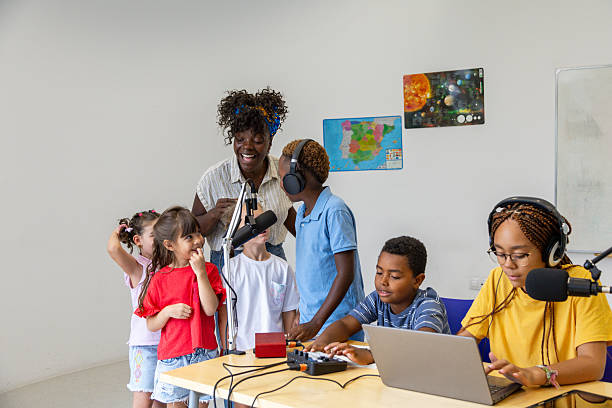 istock Elementary school students recording podcast with teacher 2228763163