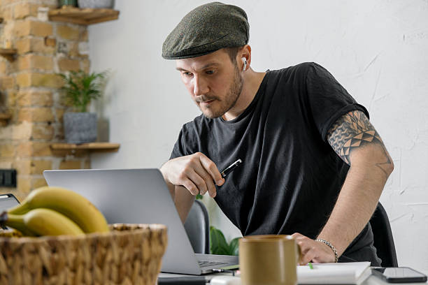 istock Focused man working from home in a modern workspace with plants and a laptop 2228763218