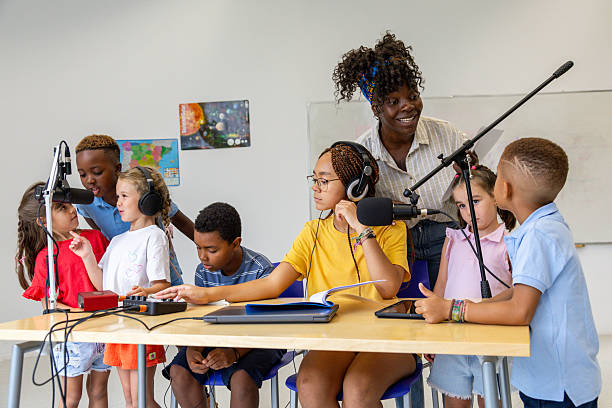 istock Elementary school students recording podcast with teacher 2228766668