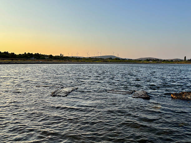 istock Calm Water and Ancient Ruins with Wind Farm on the Horizon 2228768845