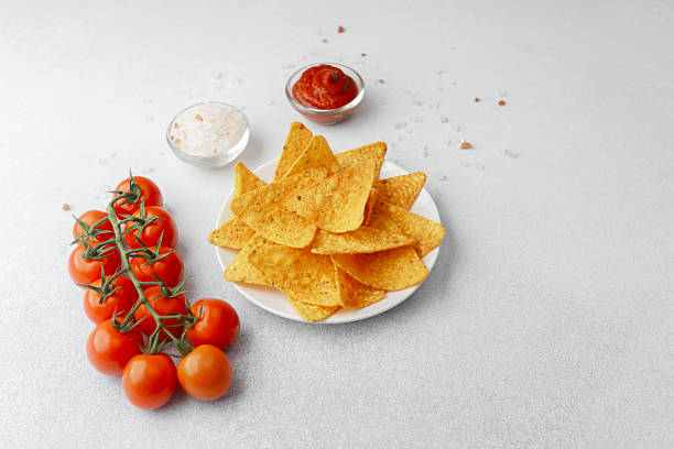 istock Crispy nachos with tomatoes, salsa and salt on white background 2228770466