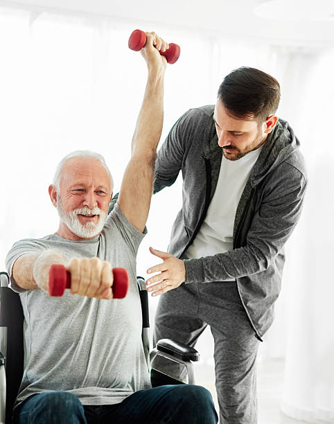 istock senior care exercise physical therapy exercising help assistence retirement home physiotherapy physiotherapist fitness gym strech band clinic therapist elderly man 2228772747