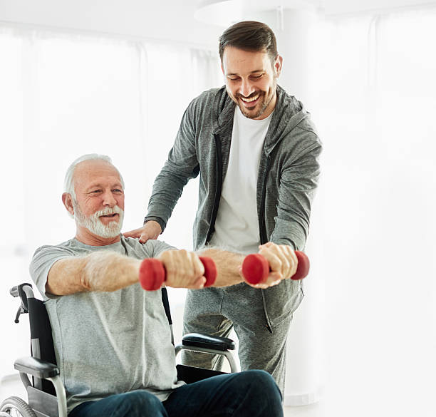 istock senior care exercise physical therapy exercising help assistence retirement home physiotherapy physiotherapist fitness gym strech band clinic therapist elderly man 2228773266
