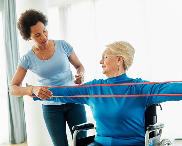 istock senior care exercise physical therapy exercising help assistence retirement home physiotherapy physiotherapist fitness gym strech band clinic therapist elderly woman band stretching 2228773610