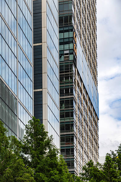 istock Modern High-Rise Building with Trees and Glass Exterior in Urban Setting 2228773973