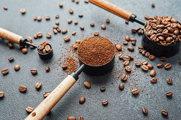 istock Ground coffee and beans in measuring scoops on dark background 2228774102