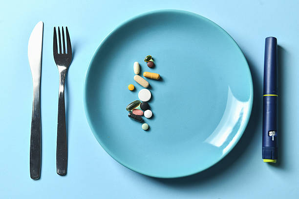istock Multiple Colorful Pills Placed On Blue Plate With Insulin Pen On Side 2228774336