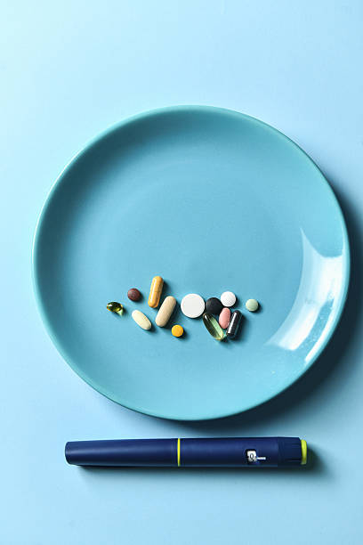 istock Multiple Colorful Pills Arranged On Blue Plate Next To Insulin Pen On Side 2228774348