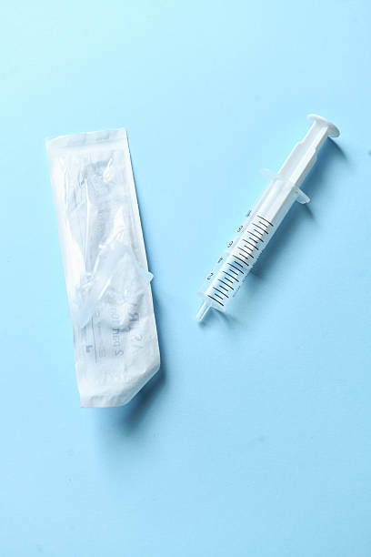 istock Sterile Syringe Ready For Use Placed Neatly On Clean Blue Medical Background 2228776126