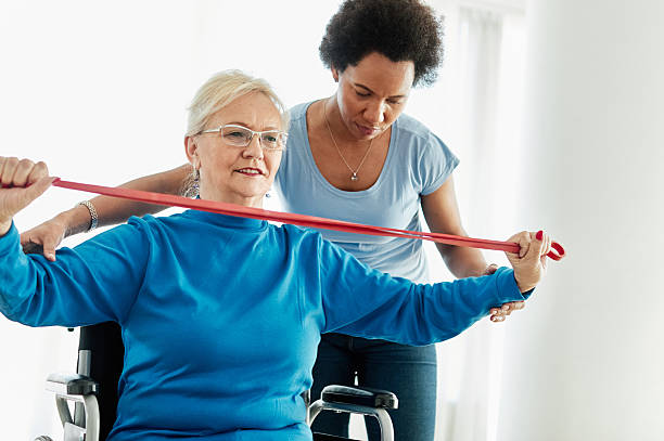 istock senior care exercise physical therapy exercising help assistence retirement home physiotherapy physiotherapist fitness gym strech band clinic therapist elderly woman band stretching 2228777361