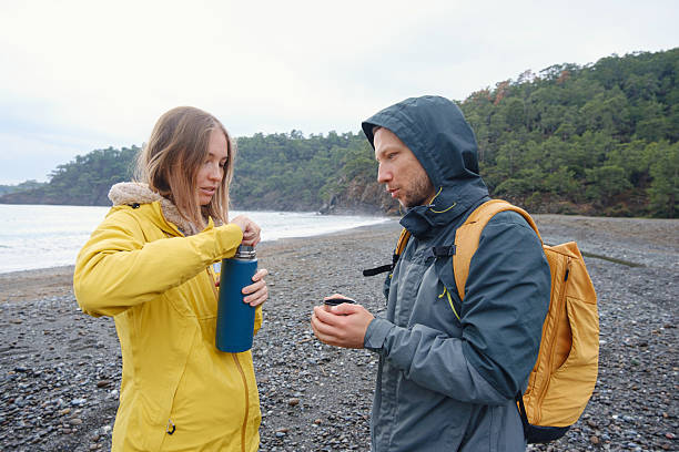 istock Couple drinks tea by winter sea shore 2228777897