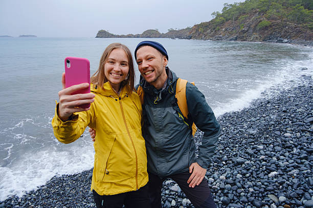 istock Couple taking selfie on beach in Winter 2228778025