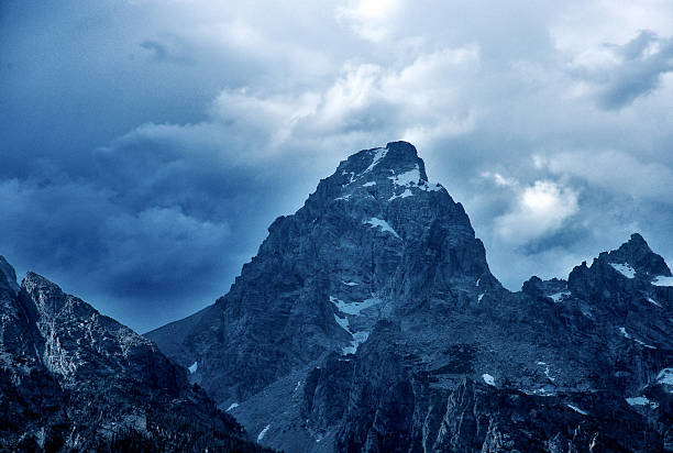 The rugged peak of the Grand Teton mountain as heavy storm cloud approach.