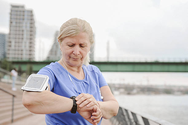 istock Outdoor Exercise: Senior Woman Checking Fitness Tracker During Workout 2228781004