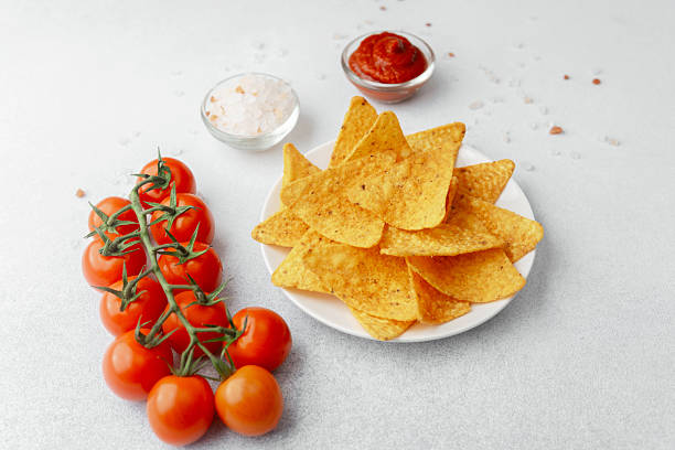 istock Crispy nachos with tomatoes, salsa and salt on white background 2228781307