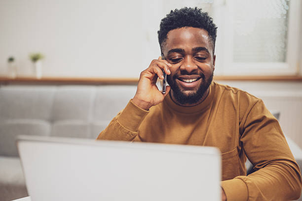 istock African remote worker using mobile phone and laptop at home 2228782245