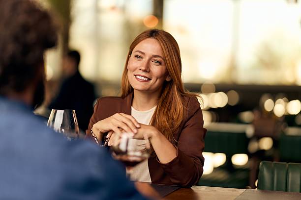 istock Smiling Woman Socializing During a Relaxed Conversation in a Modern Restaurant 2228783010