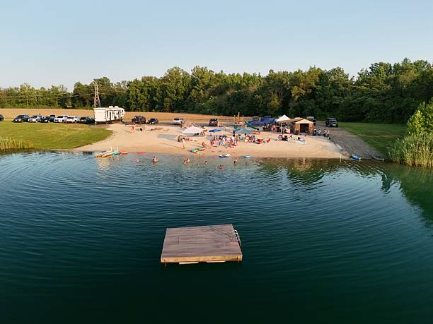 Lakeside beach with people enjoying a sunny day.