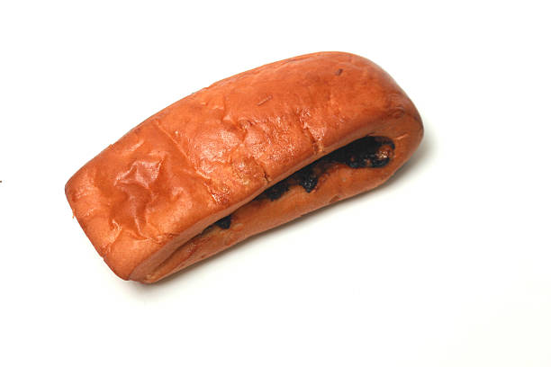 Close-up on a Latin American employee working at an industrial bakery doing quality control on packages of bread - food processing plant