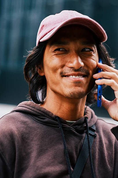 istock Smiling Young Asian Tech Executive on Phone Call in Modern City. 2228794203