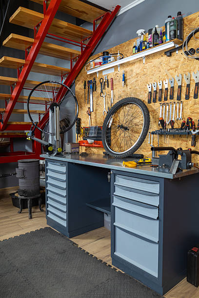 istock Bike workshop with metal workbench holding bicycle wheel tools hanging 2228794353