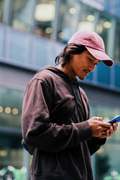 istock Smiling Young Asian Tech Executive on Phone Call in Modern City. 2228794418