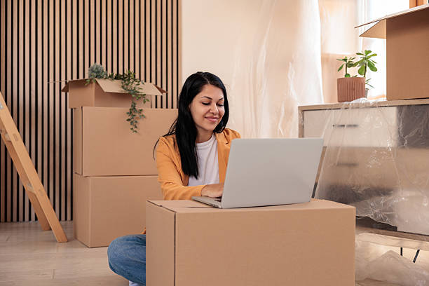 istock Woman Using Laptop to Connect New Home to Internet During Move-In 2228794675