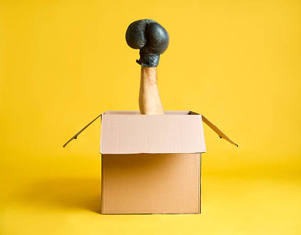 istock Hand in boxing glove raised up from open cardboard box 2228795032