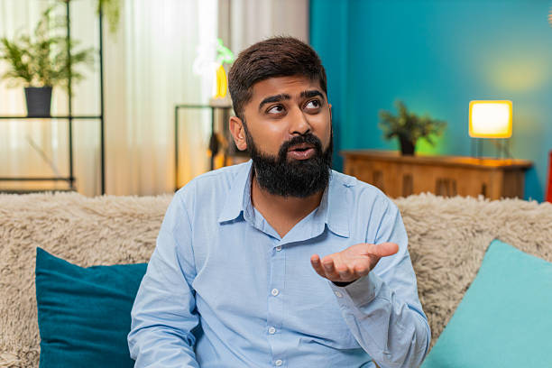 istock Indian man rolls eyes ironic reaction shows disbelief sarcasm during smartphone conversation indoors 2228796515