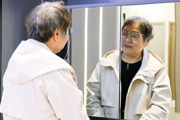 istock An elderly Asian woman is looking in the mirror. 2228796530